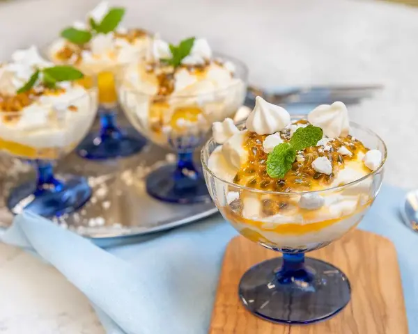 Fluffig Eton Mess med passionsfrukt och maräng i glasbägare. En härlig dessert som smälter i munnen.