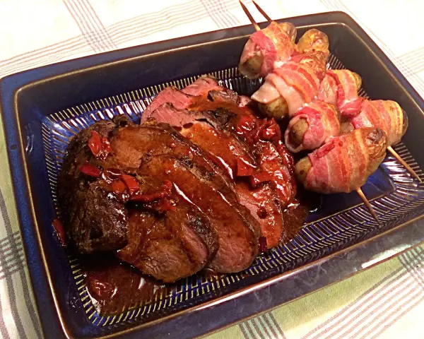 Helstekt entrecote i ugn, saftig och skivad, serveras med potatispaket inslagna i bacon. En festmåltid!