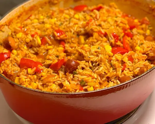 En orange gryta fylld med en smakrik jambalaya, full av ris, majs, paprika och korv. Ett perfekt recept för en mysig middag.