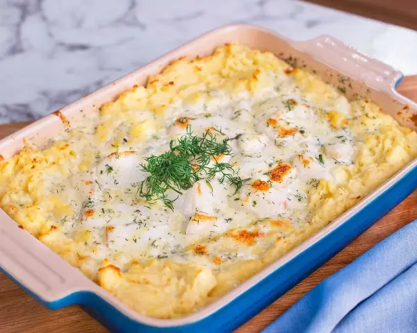 En krämig fiskgratäng med potatismos, perfekt för ett alaska pollock recept. Garnerad med färsk dill.
