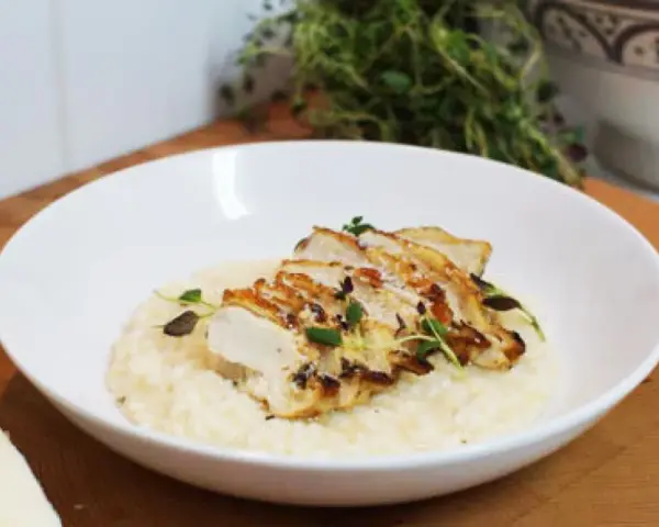 En krämig risotto med kyckling, toppad med färska örter och en bit parmesan. En perfekt risotto med kyckling för en härlig middag.