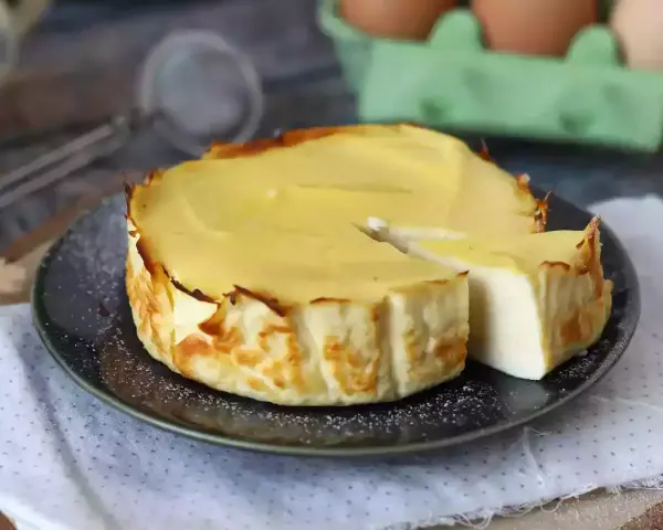 En krämig ricotta cheesecake, perfekt för ett enkelt ricotta recept. En bit är uppskuren och visar den lena insidan.