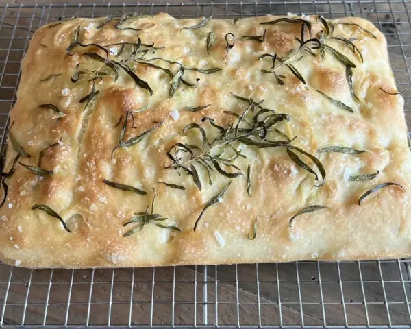 En gyllene, nybakad focaccia med rosmarin och flingsalt, perfekt för ditt nästa focaccia recept.