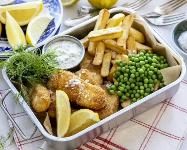 En krispig fiskgratäng med pommes frites, ärtor och citron. Perfekt för en snabb middag som hela familjen älskar.
