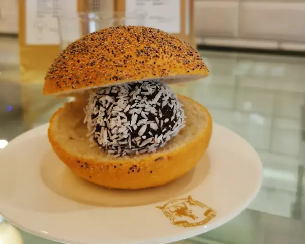 En bulle med bulle: en chokladboll med kokosflingor inuti en delad bulle med vallmofrön.