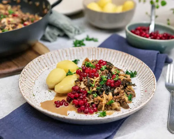 En tallrik med köttfärs och kål, serverad med kokt potatis och lingon. Ett härligt kålmaja recept som ser utsökt ut!
