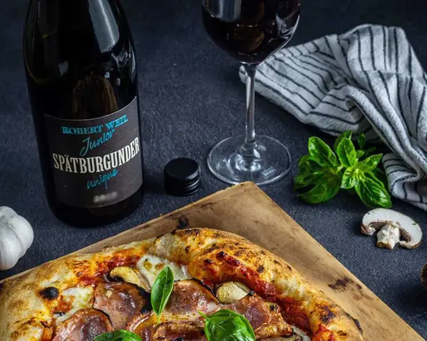 En pizza med svamp och skinka, en flaska Spätburgunder och ett glas rött vin. Perfekt vin till gås!