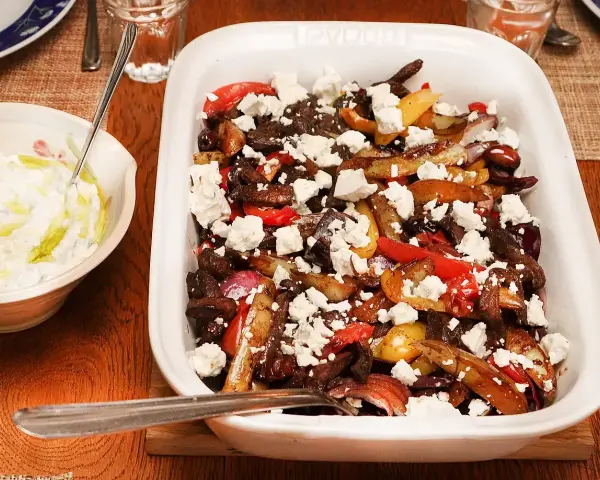 En härlig grekisk pyttipanna med potatis, paprika, lök och oliver, toppad med fetaost. Serveras med en krämig tzatziki.