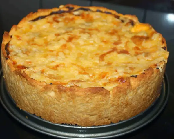 En gyllene kycklingpaj med ostigt täcke, perfekt för ett mysigt kycklingpaj recept.