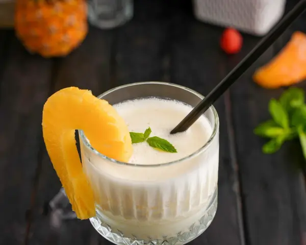 En krämig pina colada med ananasskiva och mynta. Perfekt för en solig dag.