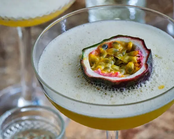 En lyxig Pornstar Martini med passionsfrukt som garnityr, serverad i ett elegant martiniglas.