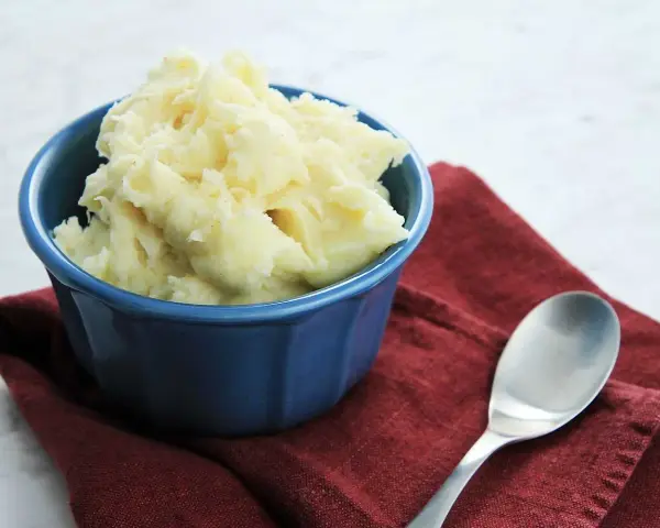 Krämigt potatismos i en blå skål, redo att serveras. Ett enkelt potatismos recept som passar till det mesta.