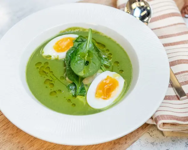 En krämig spenatsoppa med halverat kokt ägg och färsk spenat. Ett enkelt och gott spenatsoppa recept.