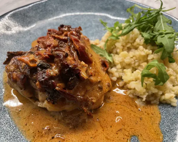 Kyckling i krämig sås med soltorkade tomater och en sida av bulgur med ruccola.