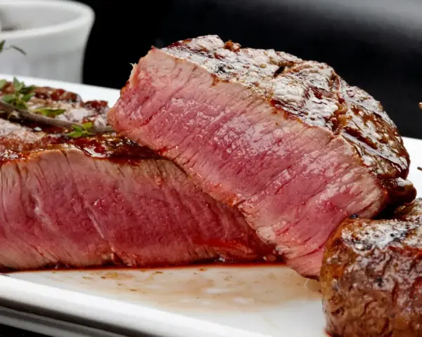 Perfekt grillad oxfilé med saftig rosa kärna, serverad med en glansig glaze och färsk timjan.