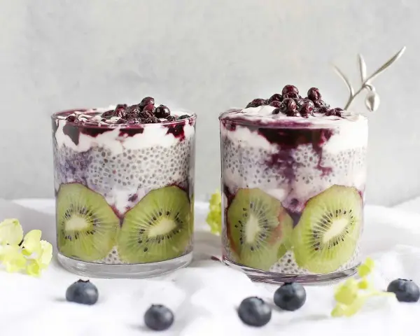 Två glas med chiapudding kvarg, kiwi och blåbär. En härlig frukost eller mellanmål.