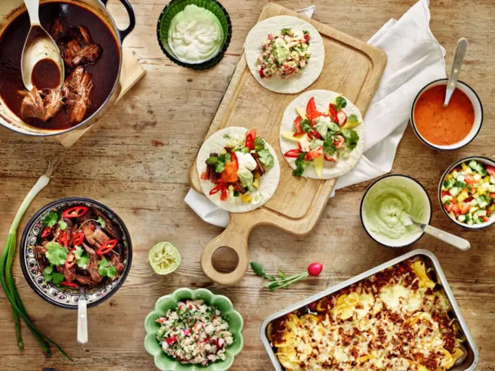 En härlig dukning med tacos, gryta med kött, salsa och guacamole. Perfekt för en mysig kväll med vin till tacos.