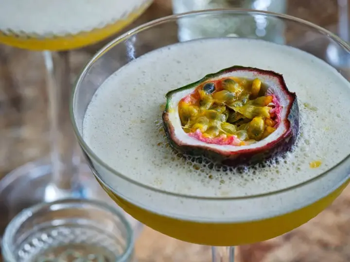 En lyxig Pornstar Martini med passionsfrukt som garnityr, serverad i ett elegant martiniglas.