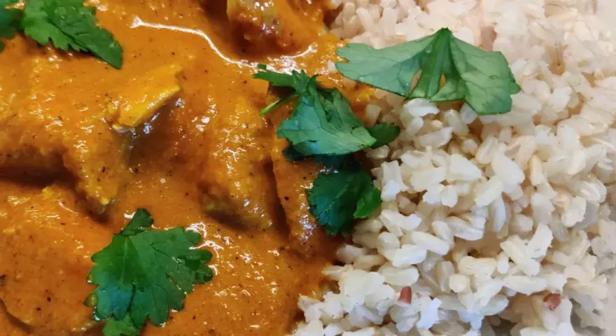 En krämig kycklingrätt med ris, perfekt för ett snabbt tikka masala recept. Garnerad med färsk koriander.