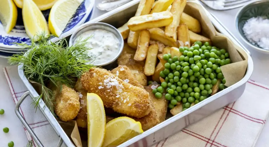 En krispig fiskgratäng med pommes frites, ärtor och citron. Perfekt för en snabb middag som hela familjen älskar.