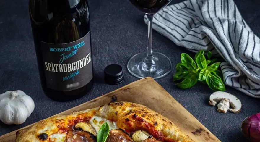 En pizza med svamp och skinka, en flaska Spätburgunder och ett glas rött vin. Perfekt vin till gås!