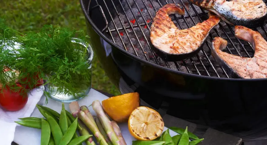 Grilla lax på gasolgrill med färska grönsaker och citron.