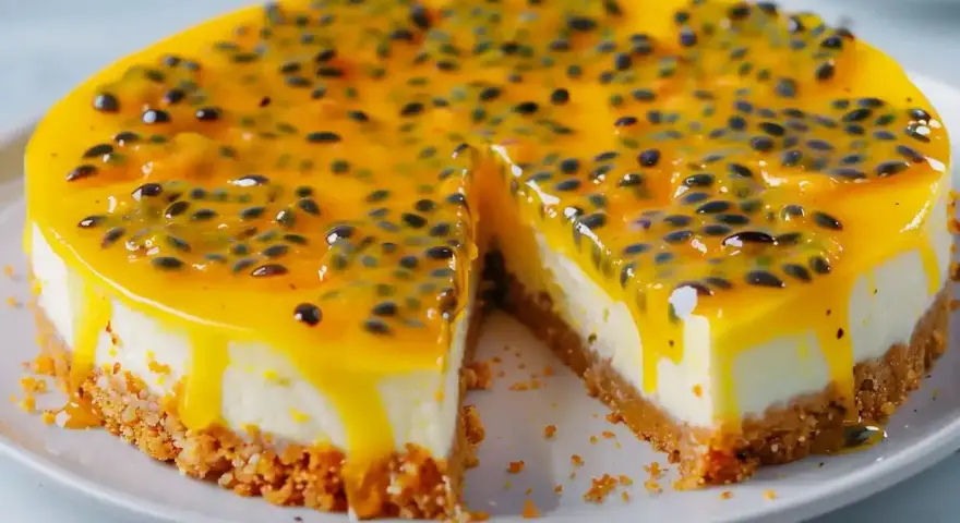 En krämig passionsfrukt cheesecake med en krispig botten och en glansig topping full av passionsfruktfrön.