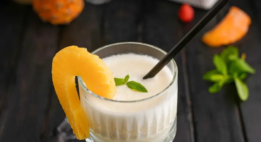 En krämig pina colada med ananasskiva och mynta. Perfekt för en solig dag.