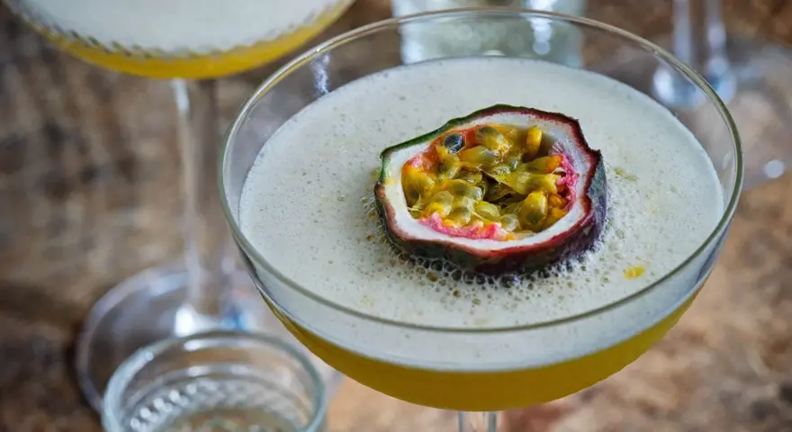 En lyxig Pornstar Martini med passionsfrukt som garnityr, serverad i ett elegant martiniglas.