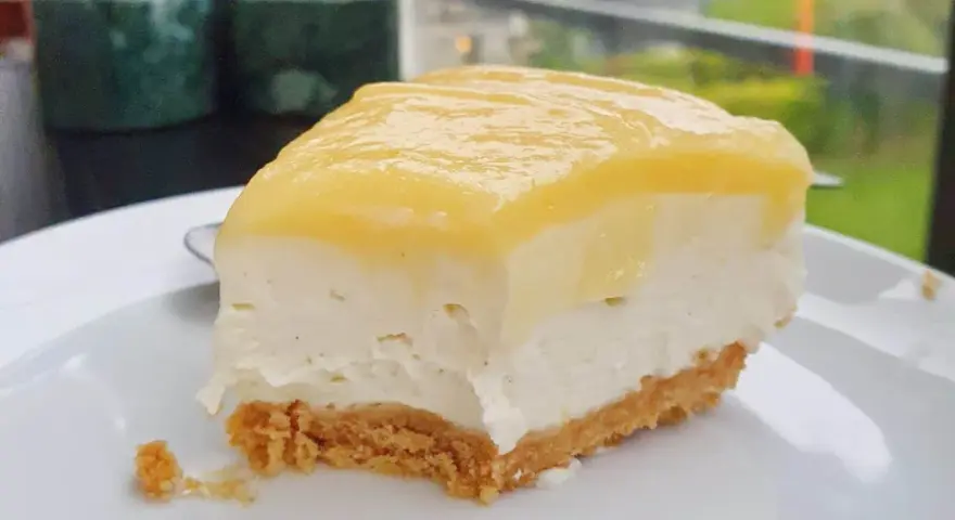 En krämig bit citron cheesecake med krispig botten, perfekt för en fika.