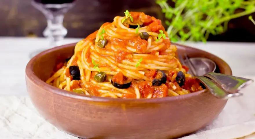 En härlig portion spaghetti med en smakrik tomatsås, oliver och kapris. Perfekt vin till pasta puttanesca.