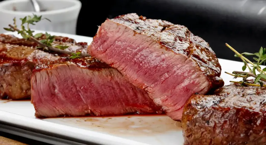 Perfekt grillad oxfilé med saftig rosa kärna, serverad med en glansig glaze och färsk timjan.