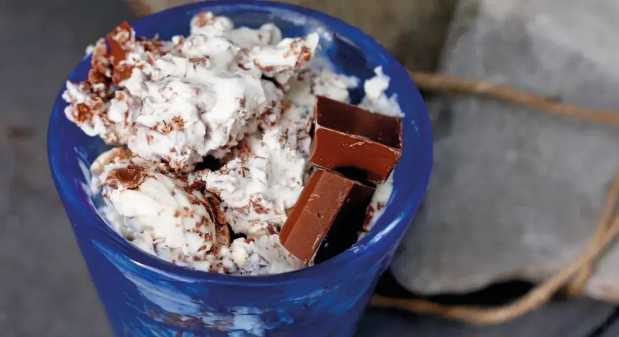 Blå skål med krämig glass, chokladbitar och strössel. Ett enkelt glass recept för en varm sommardag.