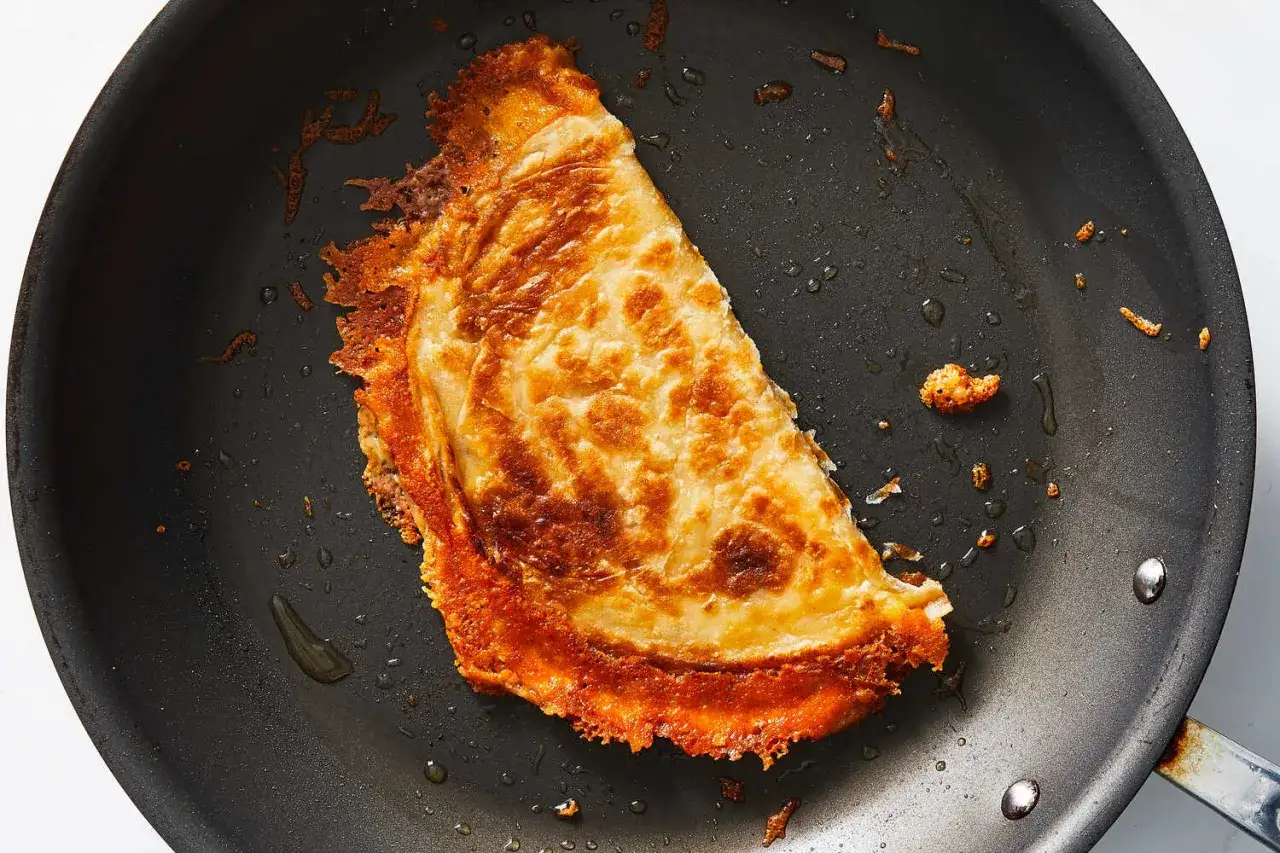 En gyllene, krispig quesadilla steks i en panna. Perfekt för ett snabbt quesadillas recept.