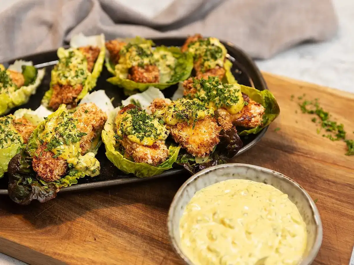 Krispiga bitar i salladsblad, toppade med en krämig sås. Perfekt tillbehör till ditt remouladsås recept.