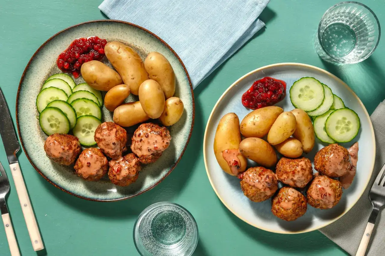 Två tallrikar med köttbullar, potatis, gurka och lingonsylt. Perfekt middagstips helg för hela familjen.