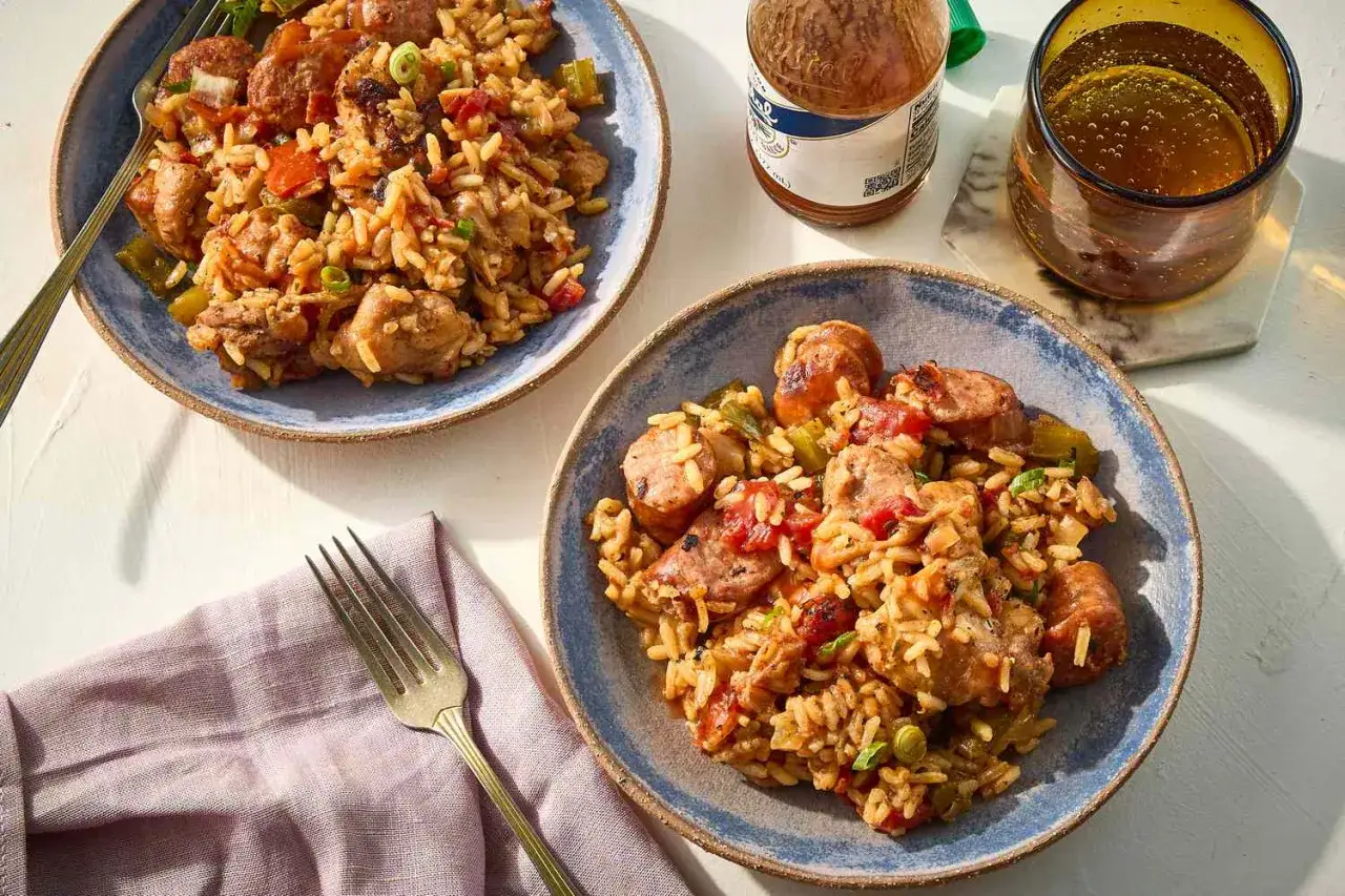 Två tallrikar med mustig jambalaya, fulla med ris, kyckling och korv. Perfekt för ett smakrikt jambalaya recept.