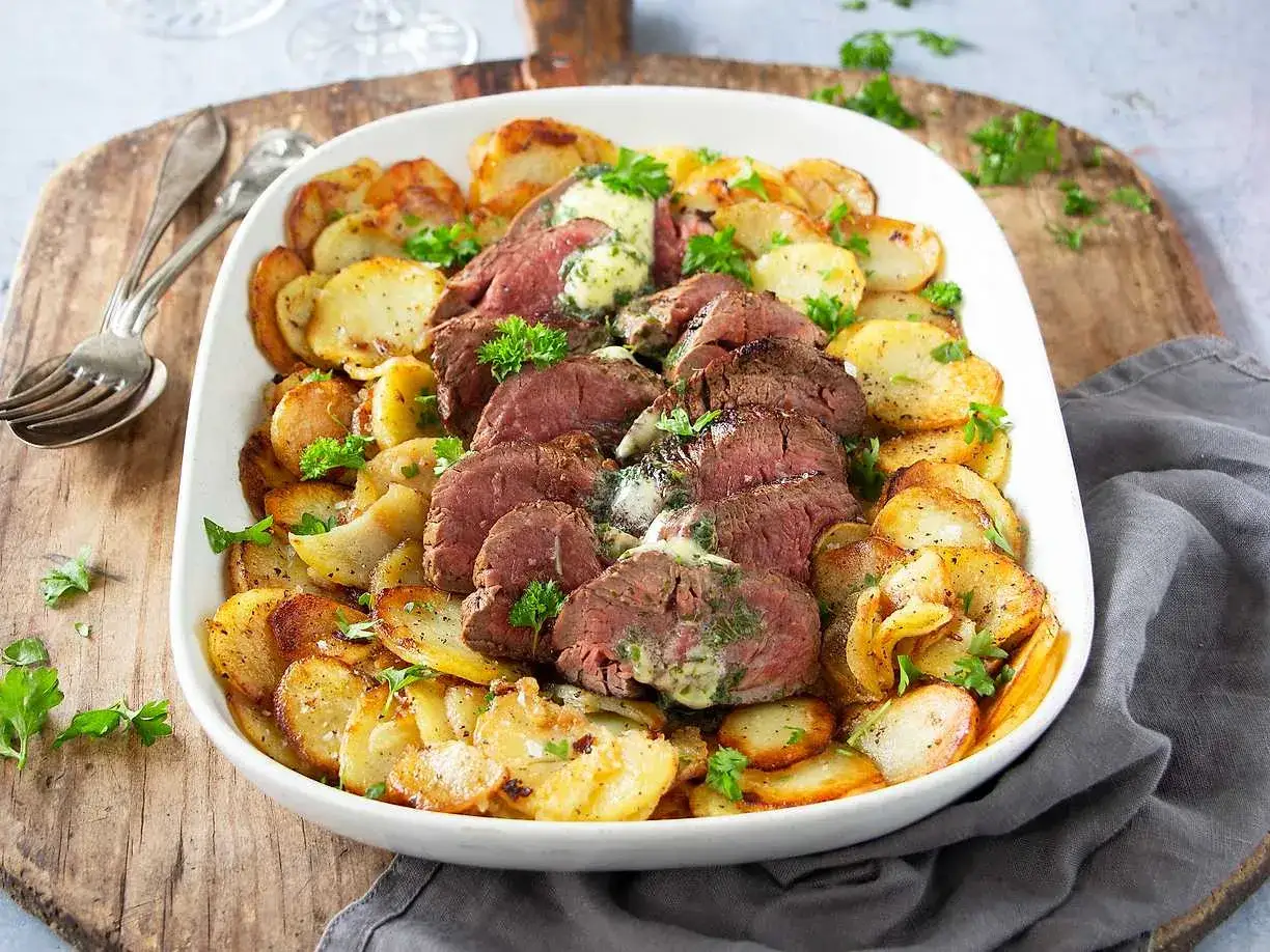 Skivat coeur de filet provencale med smält örtsmör, serverat med gyllene, krispiga potatisskivor och färsk persilja. En festlig måltid!