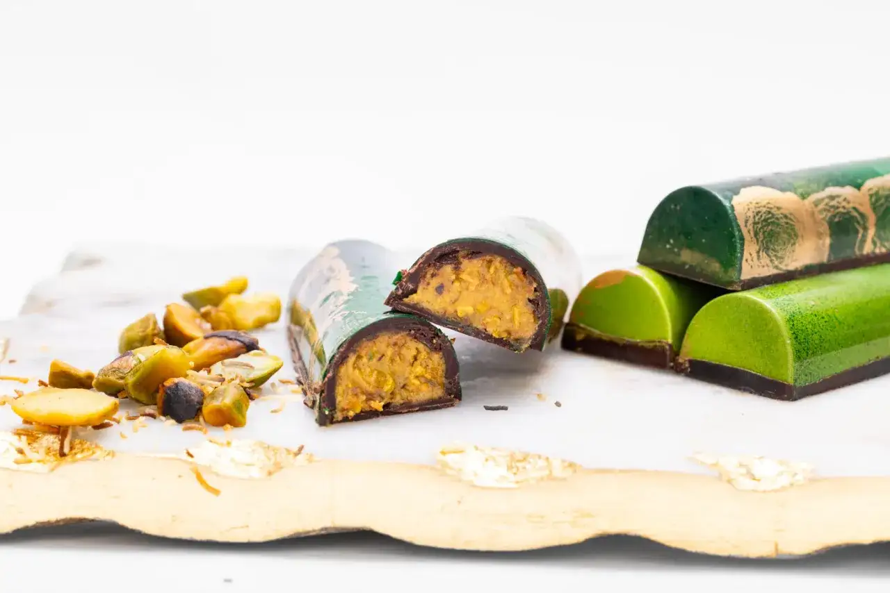 Lyxiga praliner med fyllning av nötter och dadlar, inspirerade av ett dubai choklad recept. Gröna och guldfärgade.