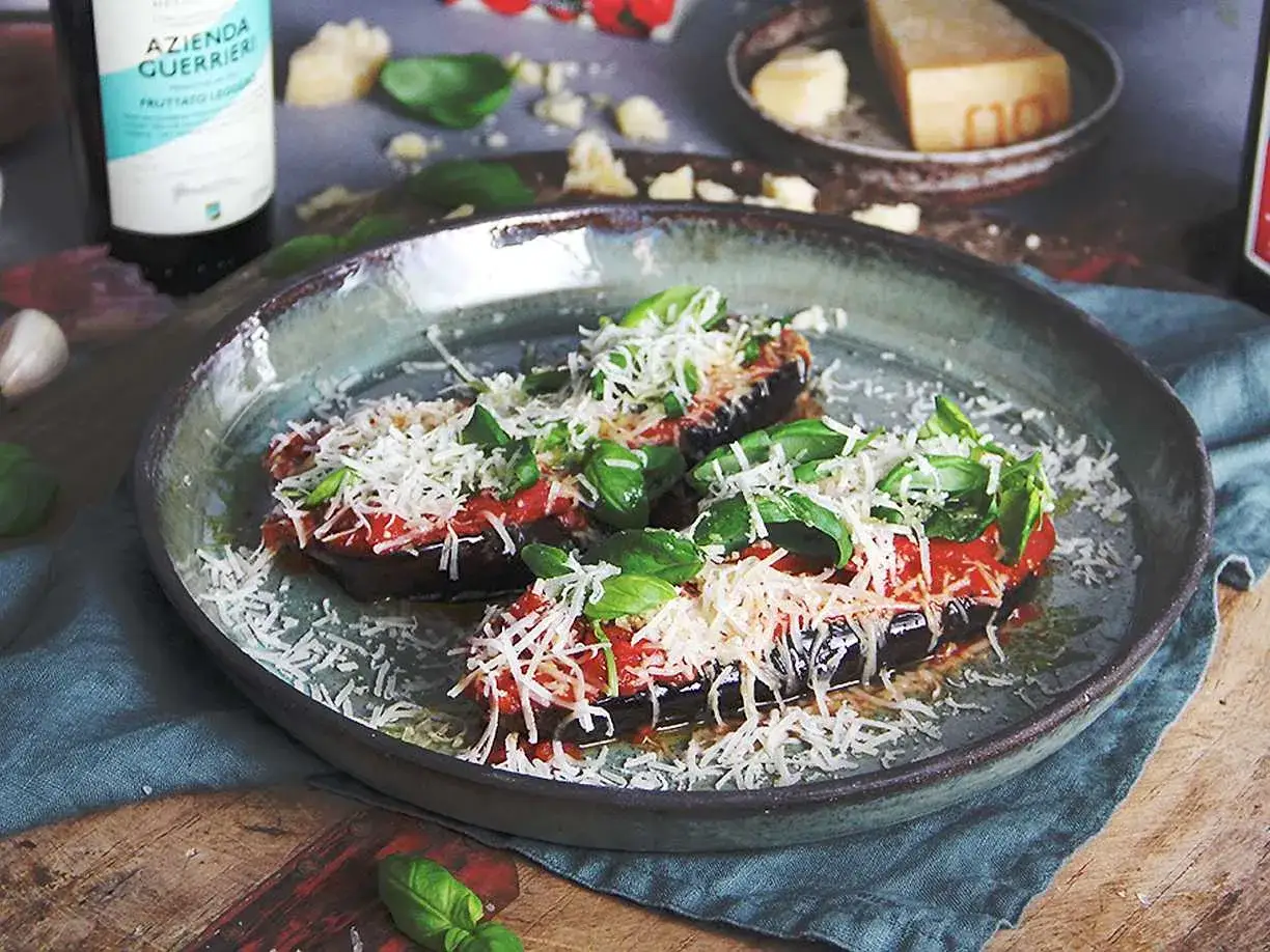 Aubergine i ugn, toppad med tomatsås, basilika och rikligt med parmesanost. En härlig italiensk rätt som doftar sommar.