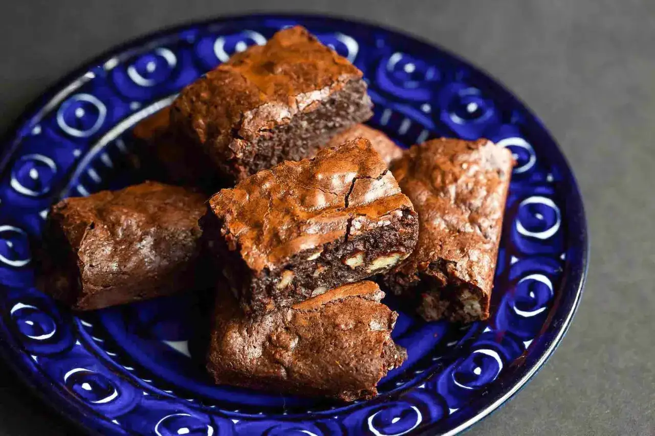 Färska, sega brownies med nötter på en blåmönstrad tallrik. Perfekt för ett enkelt brownie recept.