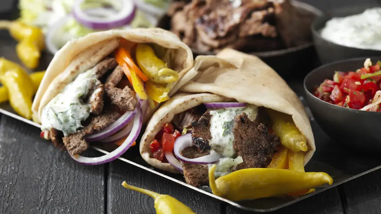 Två gyros i pitabröd med kött, grönsaker och sås. Ett perfekt gyros recept för en snabb och god middag.