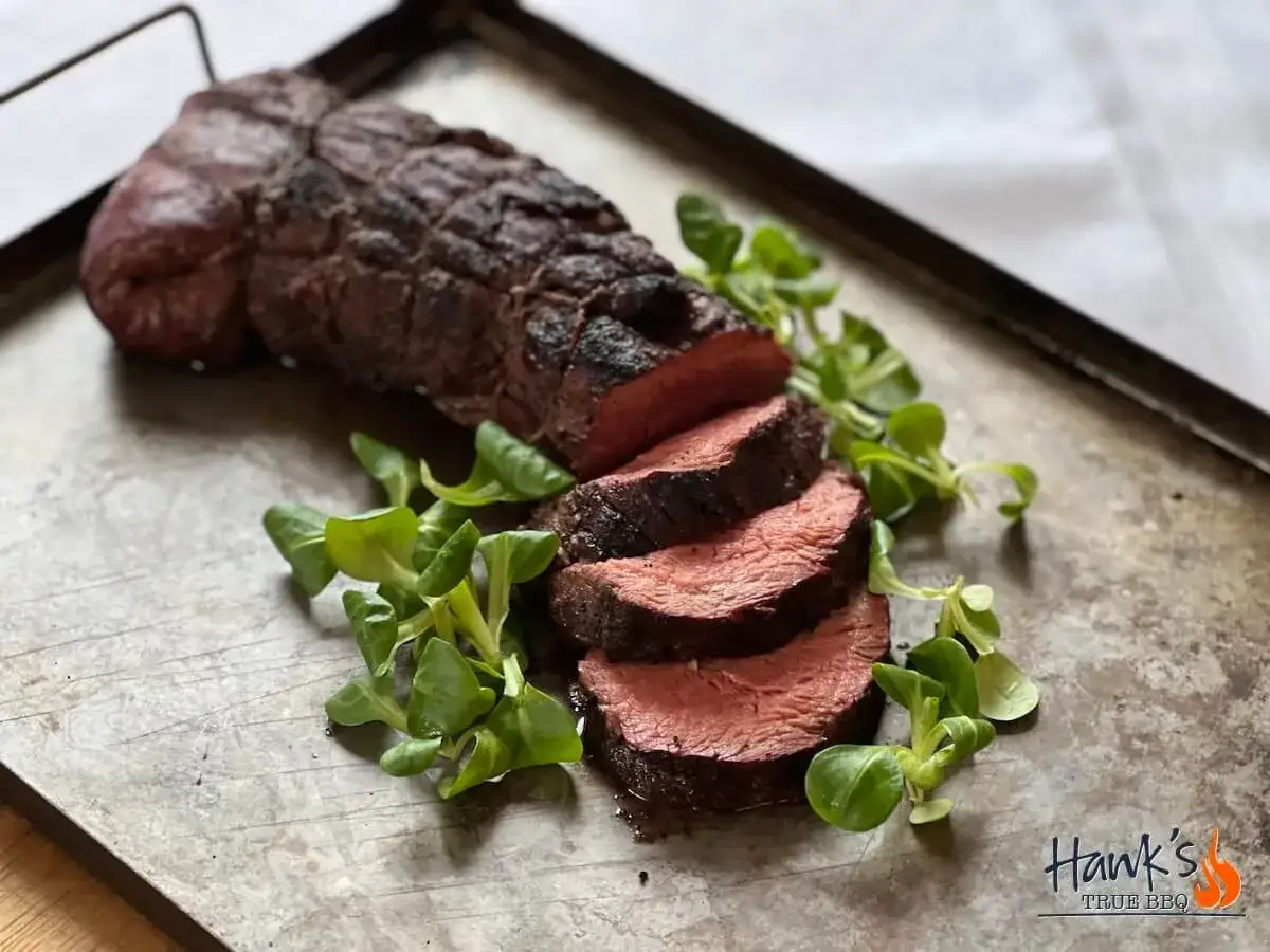 Perfekt grillad oxfilé, saftig och röd inuti, serverad med färska gröna blad. En fest för ögat och gommen!
