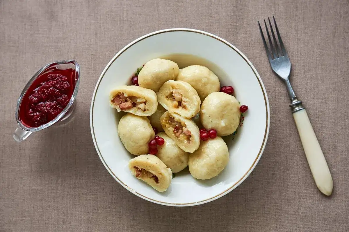 En skål med kroppkakor, fyllda med fläsk och lök, serveras med lingonsylt. Ett recept på dessa klassiska svenska dumplings.