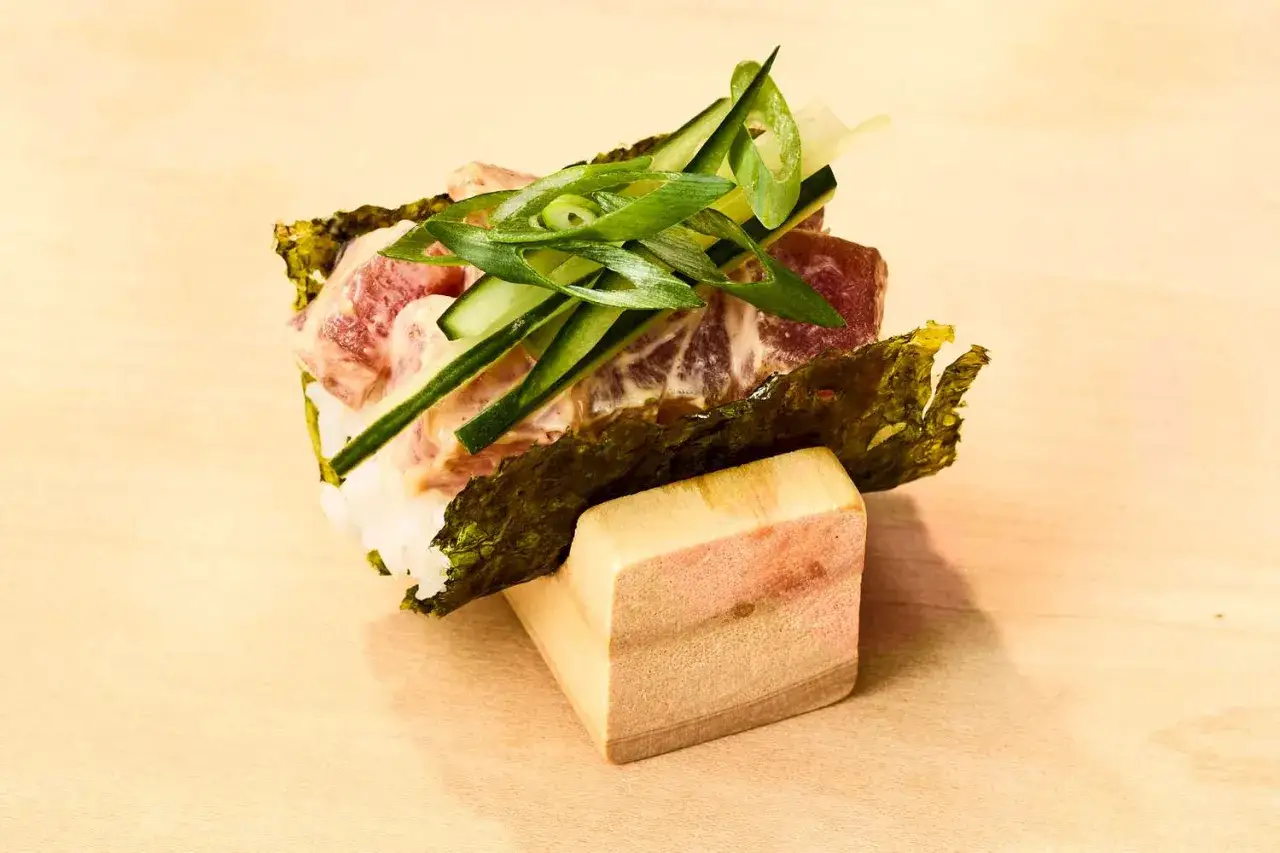 En läcker sushi-bit med rå tonfisk, gurka och salladslök på ris, inlindad i nori. Ett enkelt sushi recept att prova!