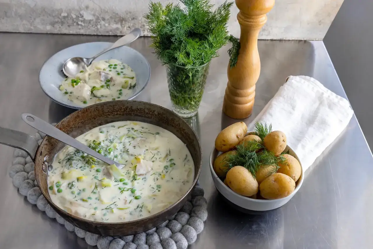 En krämig fiskgryta med ärtor och dill, serverad med nykokt potatis.