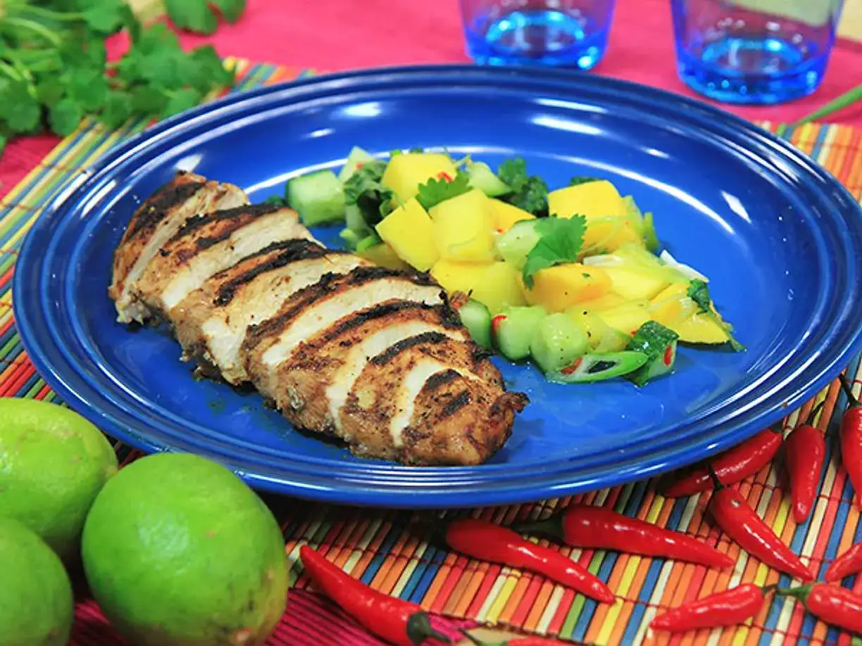 Grillad jerk chicken med mangosallad, lime och chili. En smakrik rätt som passar perfekt för en somrig middag.