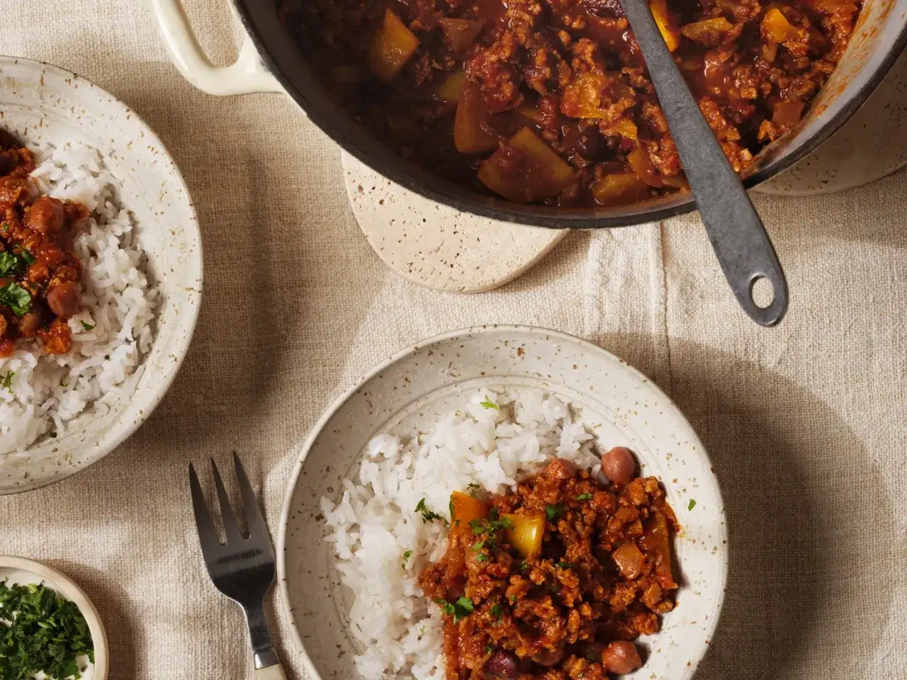 En skål med ris och en mustig chili sin carne. Grytan i bakgrunden är full av smakrik chili.