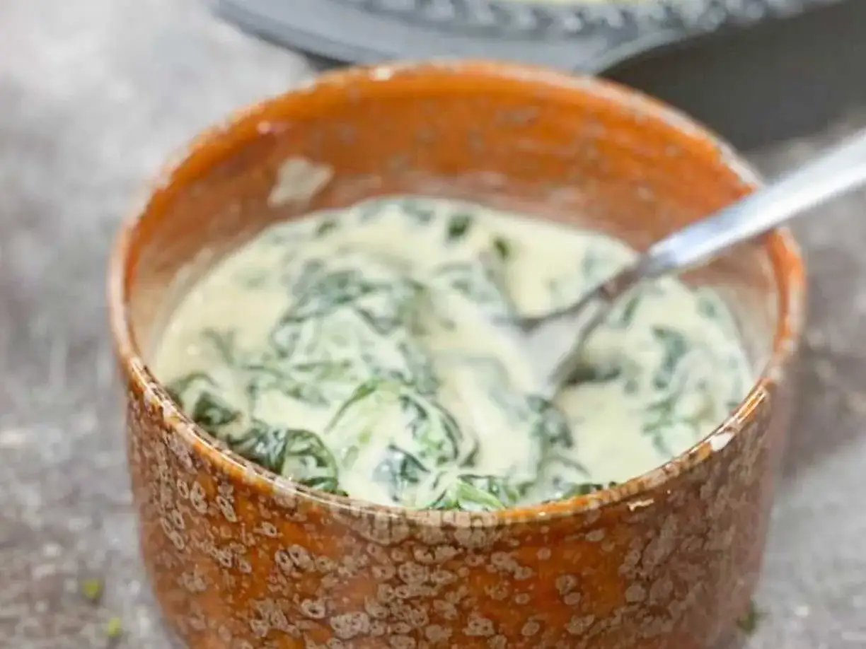 En sk&aring;l med kr&auml;mig stuvad spenat, perfekt som tillbeh&ouml;r till en klassisk svensk m&aring;ltid.