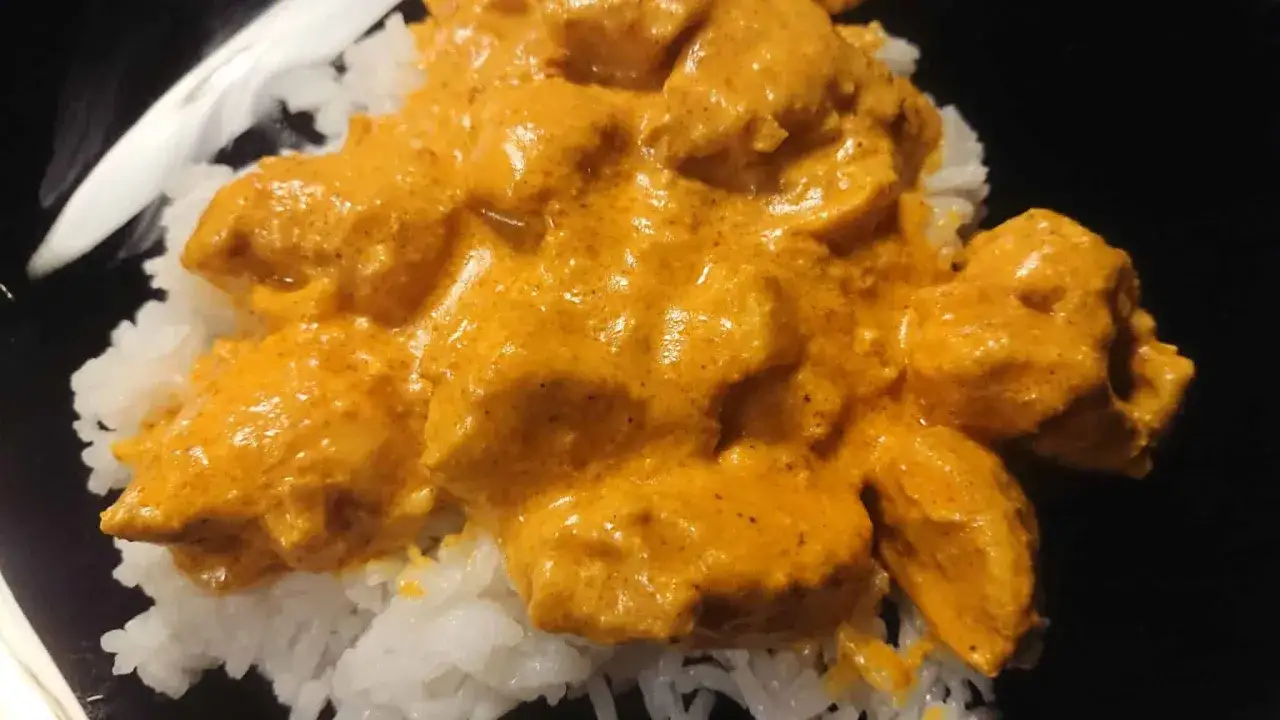 En krämig kyckling tikka masala serverad över fluffigt vitt ris. En härlig indisk rätt som värmer själen.